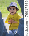 A 3-year-old boy having a good time in the park 76917869
