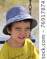 A 3-year-old boy having a good time in the park 76917874