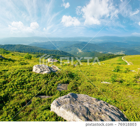 summer mountain landscape with stones on the hill. wonderful view in to the distant valley on a sunny morning. fluffy clouds above horizon summer mountain landscape with stones on the hill. wonderful view in to the distant valley on a sunny morning. fluffy clouds above horizon 76918803