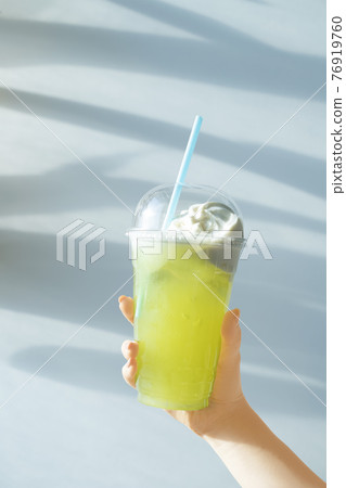 Female hand holding a float under the palm tree [Pale tone] 76919760