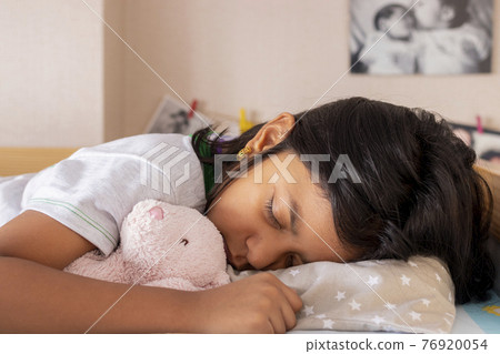 Little girl sleeping on her bed inside her room 76920054