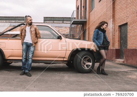 young woman and her boyfriend standing near the car 76920700