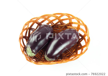two ripe eggplant in a wicker basket.isolated on white. 76922022
