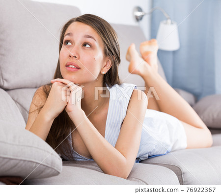 Young female is posing on sofa 76922367