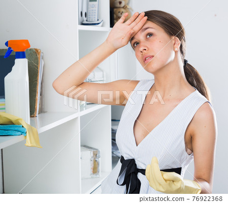 Young woman is resting after cleaning Young woman is resting after cleaning 76922368