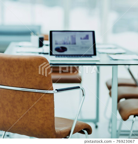 open laptop computer with financial charts on the table with the Manager in a modern office. open laptop computer with financial charts on the table with the Manager in a modern office. 76923067