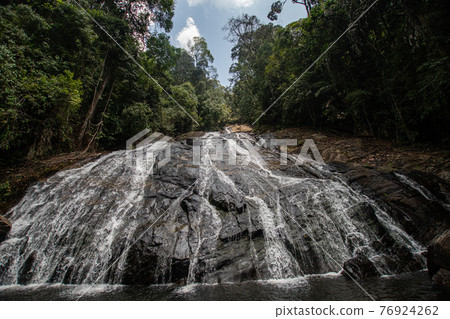Picturesque waterfall in Sri Lanka. cascades of water fall down on rocky ledges 76924262