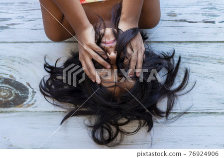 Close up of brunette teenager touching her face with her hands 76924906