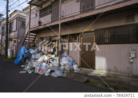 A pile of garbage, a trash house, an apartment surrounded by piles of garbage 76929711