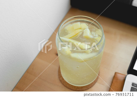 Relax summer day with Lemon Soda and working on the laptop. Work from home. 76931711