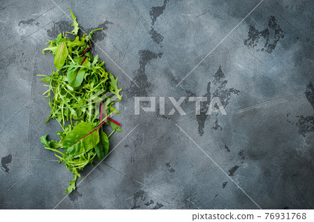 Herb green salad with arugula and Mangold, Swiss chard, on gray stone background, top view flat lay, with copy space for text Herb green salad with arugula and Mangold, Swiss chard, on gray stone background, top view flat lay, with copy space for text 76931768