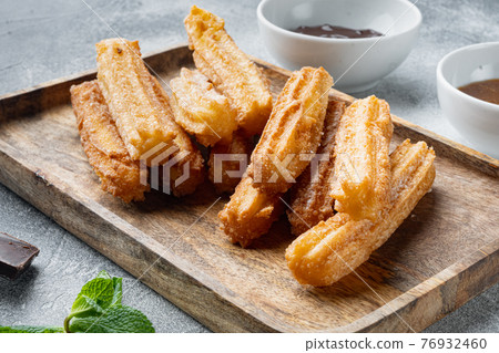Churros sprinkled with powdered sugar, on gray background 76932460