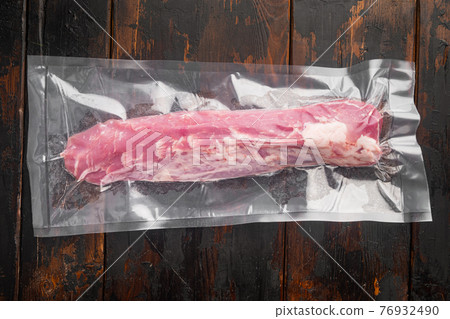 Vacuum packaging of meat products pork fillet tenderloin, on old dark wooden table background Vacuum packaging of meat products pork fillet tenderloin, on old dark wooden table background 76932490