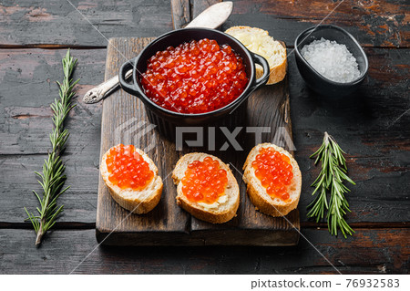 Canape toast with red caviar, on old dark wooden table background Canape toast with red caviar, on old dark wooden table background 76932583
