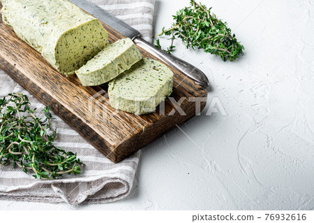Portion of Herb Butter with Chives, Basil, Oregano, Parsley, on white stone background, with copy space for text 76932616