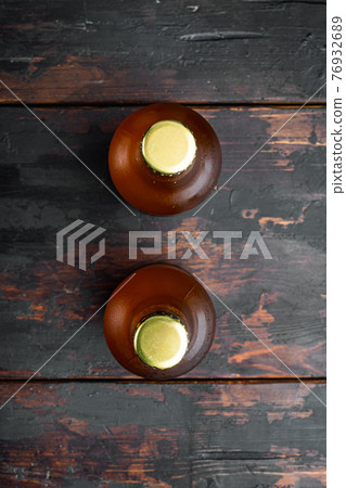 Beer bottle, on old dark wooden table , top view flat lay Beer bottle, on old dark wooden table , top view flat lay 76932689