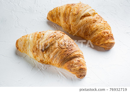 Crispy fresh croissants, on white stone background Crispy fresh croissants, on white stone background 76932719