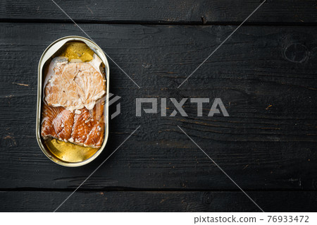 Salmon, fish preserves Canned smoked fish, in tin can, on black wooden table background, top view flat lay, with copyspace and space for text Salmon, fish preserves Canned smoked fish, in tin can, on black wooden table background, top view flat lay, with copyspace and space for text 76933472