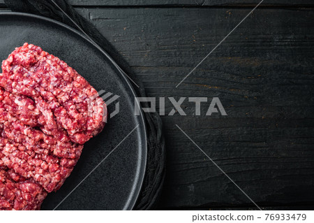 Minced meat, on black wooden table background, top view flat lay with copy space for text Minced meat, on black wooden table background, top view flat lay with copy space for text 76933479