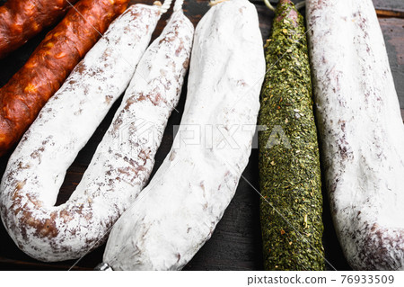 Spanish wurst hanging on wooden background Spanish wurst hanging on wooden background 76933509