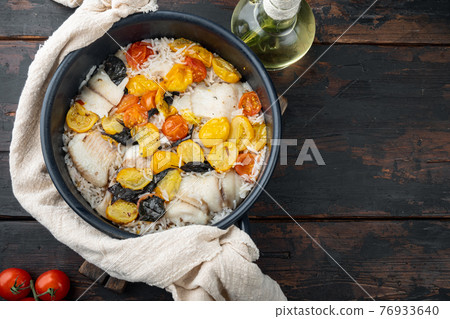 White tilapia fish with basmati rice and cherry tomatoes , on dark wooden background, top view with copy space for text White tilapia fish with basmati rice and cherry tomatoes , on dark wooden background, top view with copy space for text 76933640