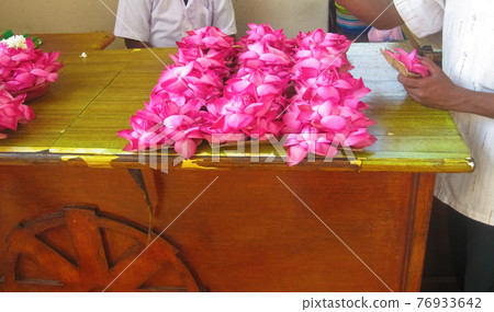 Flowers offering for a statue of Buddha 76933642