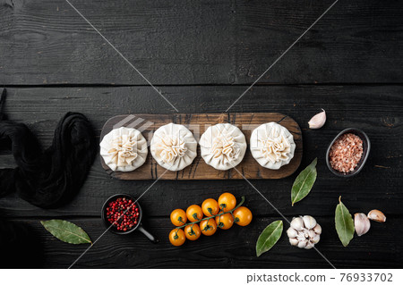 Khinkali Dumplings with beef and lamb meat, on black wooden table background, top view flat lay, with copy space for text Khinkali Dumplings with beef and lamb meat, on black wooden table background, top view flat lay, with copy space for text 76933702
