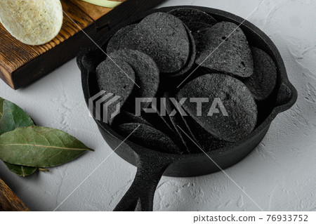 Cheese and chive potato crisp snack with Cheese and Onion , with dipping sauces tomato dip sour cream, on white stone surface 76933752