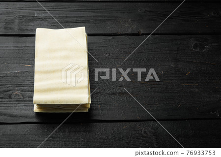 Organic lasagna pasta sheets, on black wooden table background, with copy space for text 76933753