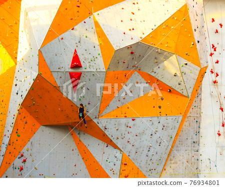 The active young woman on rock wall in sport center 76934801