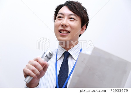 一名男性上班族使用麥克風進行演示 76935479