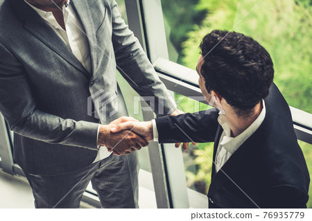 Businessmen handshake business deal in office. 76935779