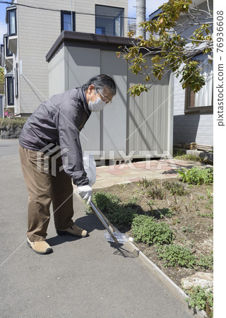 Senior men picking up garbage 76936608