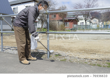 Senior men picking up garbage 76936610