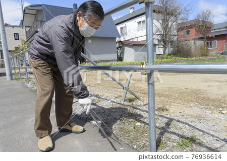 Senior men picking up garbage 76936614