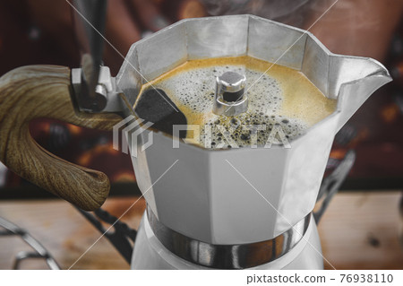 Coffee making with Moka pot and snack. Coffee making with Moka pot and snack. 76938110
