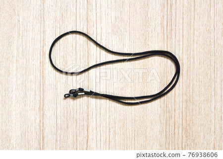 black eyeglasses strap on a wooden background 76938606