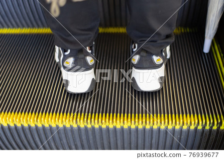 A person who stops on the right side of the escalator A person who stops on the right side of the escalator 76939677