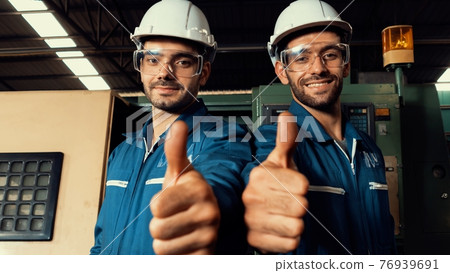 Two skillful factory engineer or worker showing teamwork and partnership . Two skillful factory engineer or worker showing teamwork and partnership . 76939691