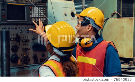 Group of skillful workers using machine equipment in factory workshop 76940933