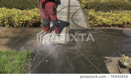 Work in progress. Floor washing, in a garden, with high pressure water. Work in progress. Floor washing, in a garden, with high pressure water. 76940938