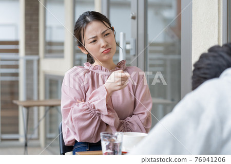 Couple quarreling in a cafe 76941206