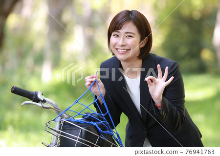 A woman who wears a bicycle net and makes a circle with her hands A woman who wears a bicycle net and makes a circle with her hands 76941763