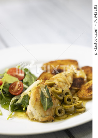 chicken breast baked on sage with green olive sauce with salad and potatoes chicken breast baked on sage with green olive sauce with salad and potatoes 76942192