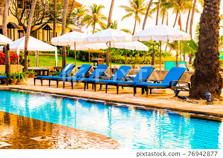 palm tree with umbrella chair pool in luxury hotel resort at sunrise times palm tree with umbrella chair pool in luxury hotel resort at sunrise times 76942877