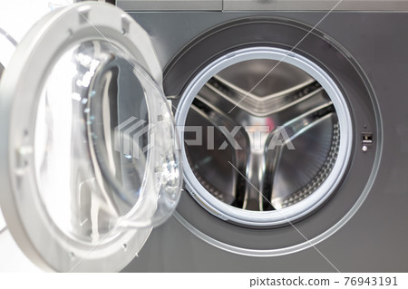 open glass door of a gray steel strip machine; drum of a washing machine. front view, close up open glass door of a gray steel strip machine; drum of a washing machine. front view, close up 76943191