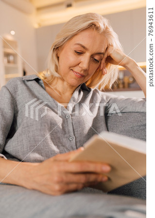 Female spending her weekend at home with favorite novel Female spending her weekend at home with favorite novel 76943611