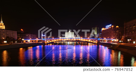 Moscow, Russia. Night. View from the embankment of the Moskva River. Borodinsky bridge, Smolensky Metro Bridge and White House of Russia behind it. Moscow, Russia. Night. View from the embankment of the Moskva River. Borodinsky bridge, Smolensky Metro Bridge and White House of Russia behind it. 76947852