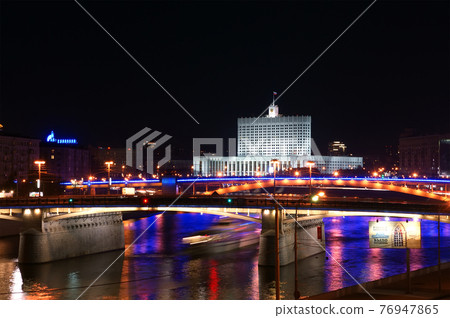 Moscow, Russia. Night. View from the embankment of the Moskva River.  Borodinsky bridge, Smolensky Metro Bridge and White House of Russia behind it. 76947865