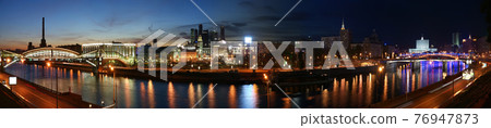 Moscow, Russia. Night. Panoramic view from the embankment of the Moskva River in the Kievsky train station, international business centre and bridges Moscow, Russia. Night. Panoramic view from the embankment of the Moskva River in the Kievsky train station, international business centre and bridges 76947873